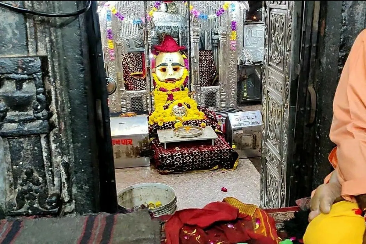Inside view of Kal Bhairav Temple in Ujjain showcasing the decorated idol with silver backdrop, flower offerings, and traditional worship setup