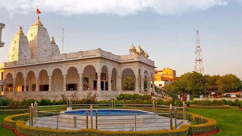 ISKCON Temple Ujjain with white marble architecture, landscaped gardens, and iconic domes under a clear sky – a popular spiritual and tourist destination in Madhya Pradesh.